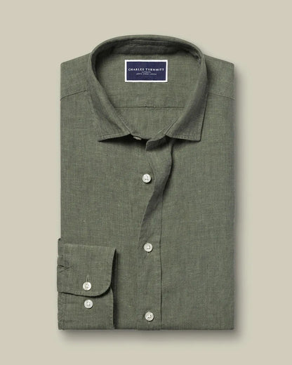 Folded green linen button-up shirt with white buttons and inner label