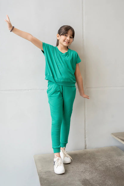 Teal kids tracksuit set with short-sleeve tee and jogger pants, arms raised pose