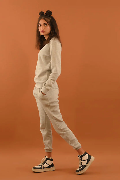 Light gray crewneck sweatshirt and jogger pants with elastic cuffs, full-length