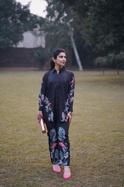 Black embroidered kurta with floral sleeve panel and matching printed pants, side view