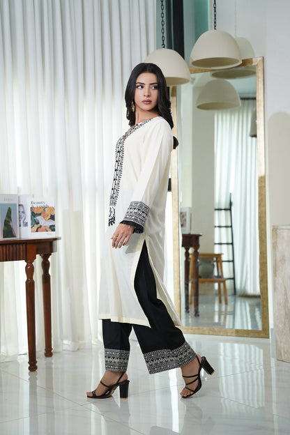 Cream kurta tunic with black side embroidery and cuffs, worn with black pants