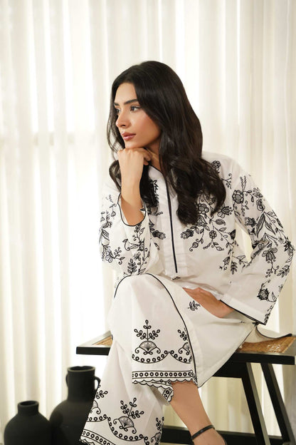White embroidered tunic with black floral print, loose sleeves and black trim
