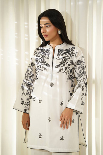 White embroidered tunic with black floral patterns and knee-length straight hem