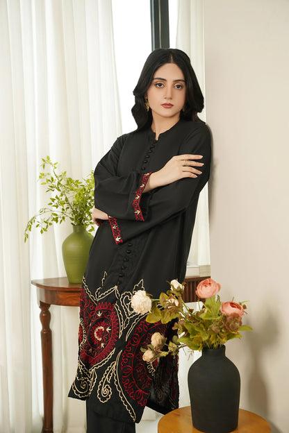 Women’s black embroidered tunic with red cuffs and ornate hem panel, matching pants