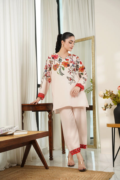 Off-white floral tunic with red cuffs and trim, paired with beige pants