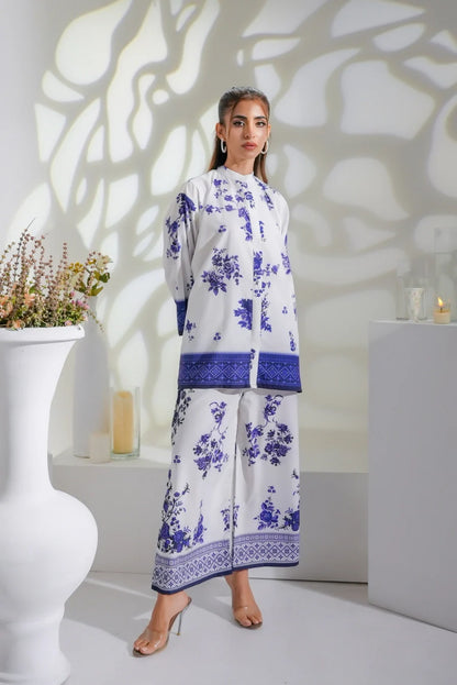 White midi dress with blue floral print, long sleeves, and navy border hem
