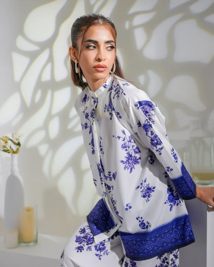 White floral midi dress with navy blue cuffs and hem, long sleeves, round neckline