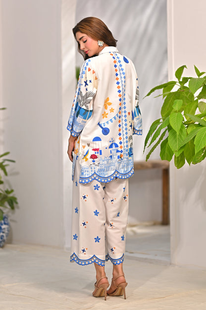 Women’s printed kurta pajama set, off-white with blue trim and colorful motifs, back view