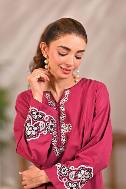 Women’s magenta kurta close-up with white embroidered neckline and floral sleeve trim