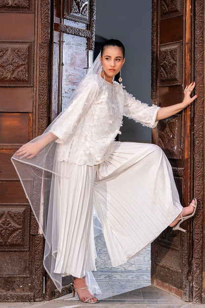 White tiered maxi dress with ruffled neckline and sheer tulle overlay