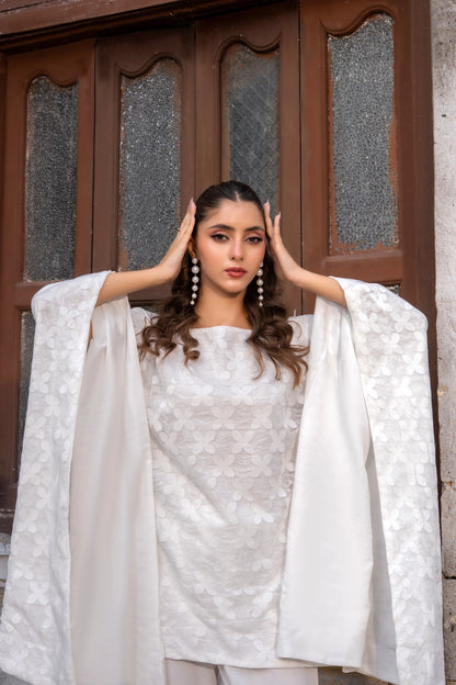 White embroidered kurta with round neckline and draped cape sleeves, close-up