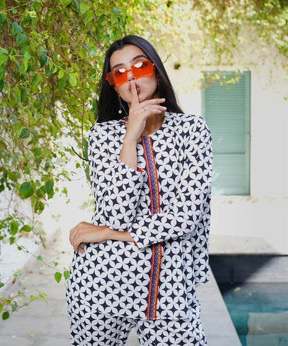 Geometric print long-sleeve jumpsuit with orange trim and round neckline