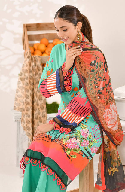 Turquoise kurta suit with floral prints and orange dupatta held on the shoulder.