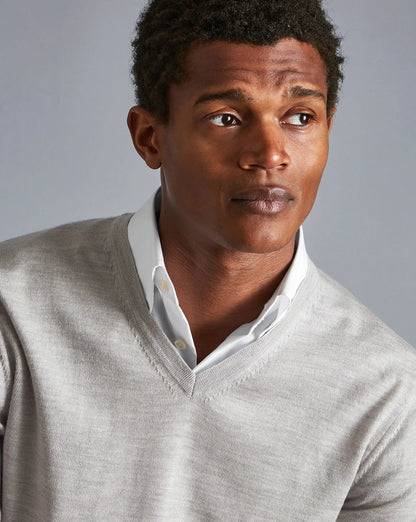 Men's grey V-neck knit sweater with ribbed neckline and white shirt underneath