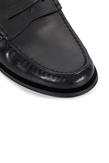 Close-up of black leather mule loafer with stitched vamp and rubber sole edge