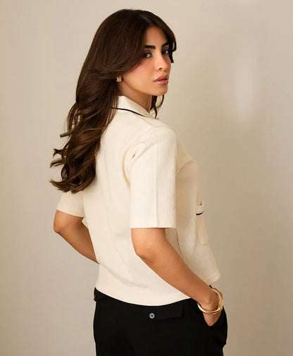 Ivory short-sleeve button-up top with stand collar and contrast-trim pocket details.