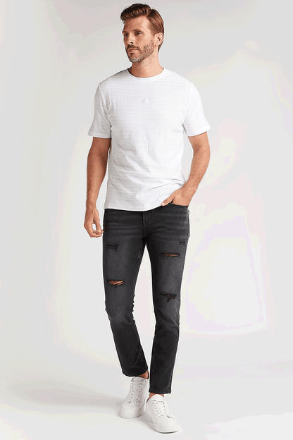 Black distressed slim-fit jeans with orange-brown patch rips and five-pocket design