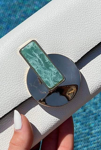 White leather clutch with green resin-style stone gold-tone clasp detail