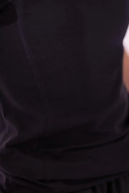 Black T-shirt fabric close-up showing smooth knit and curved hem seam