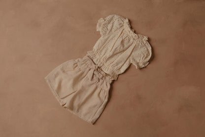 Cream shorts with elastic waist and front bow, gathered at the sides