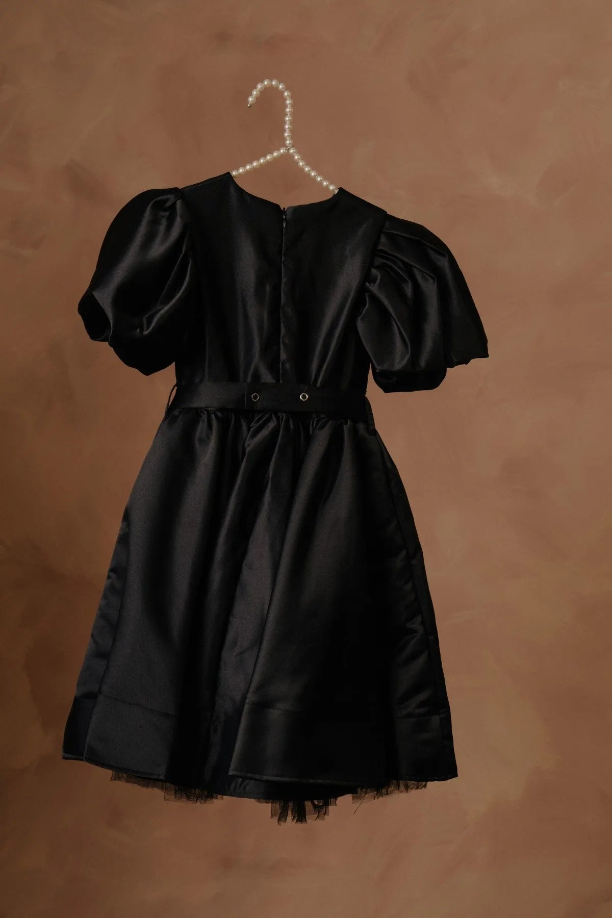 Black puff-sleeve dress with buttoned back, bow waist, tulle-trim skirt