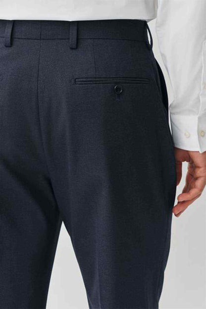 Navy suit trousers close-up of waistband, belt loops, and front pocket