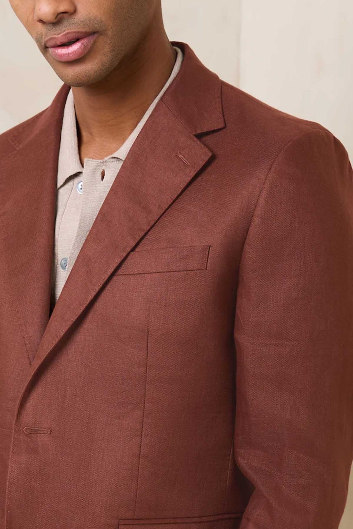 Brown blazer with notch lapel, chest welt pocket, and white shirt collar