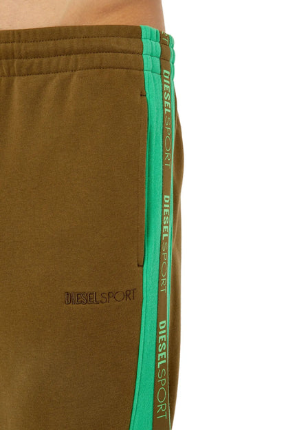Close-up of olive track pants with green side tape and stitched logo text