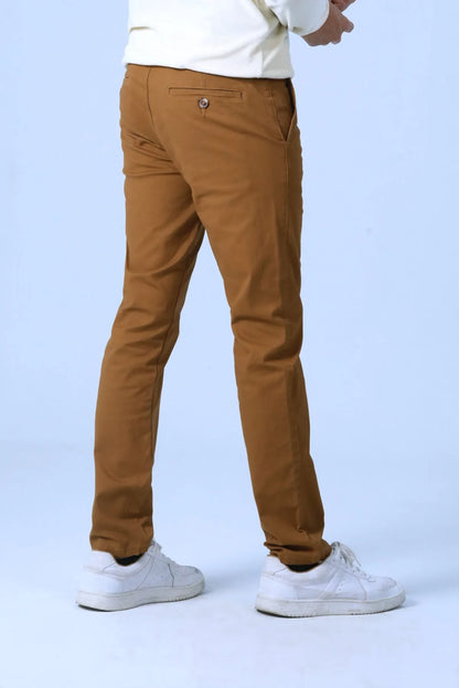 Brown pants close-up on legs with cuffed hem and visible stitching.