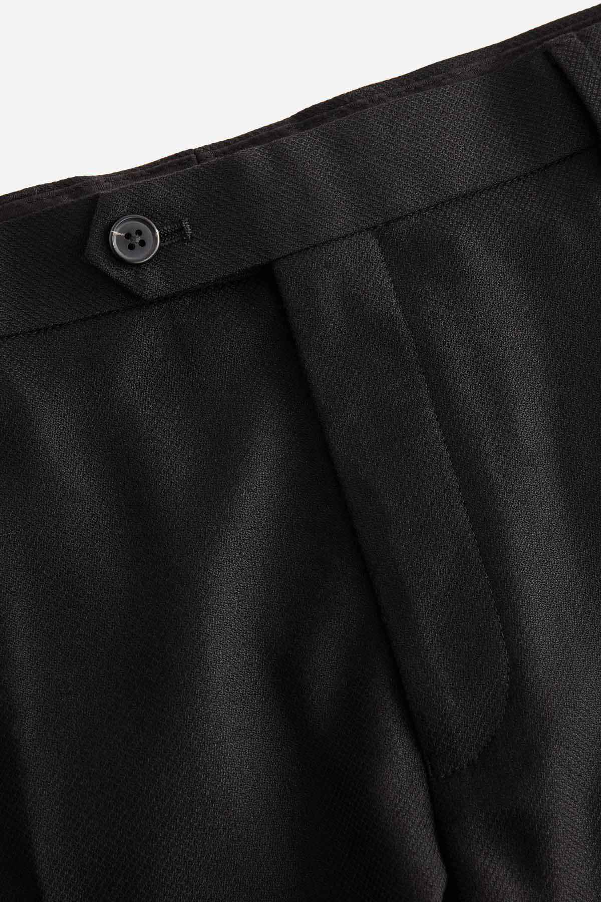 Black trouser fly button and fabric texture close-up
