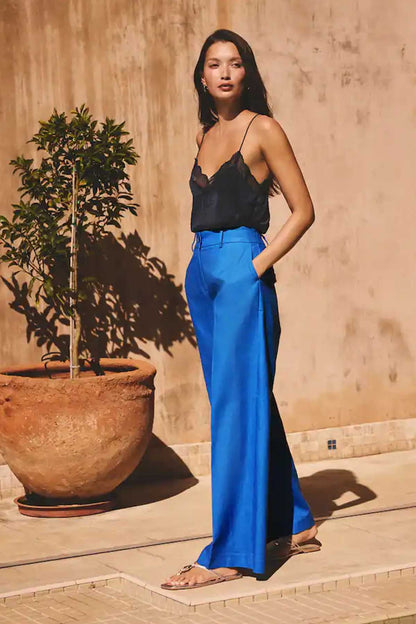 Women’s blue high-waist wide-leg trousers with subtle front pleats and long length