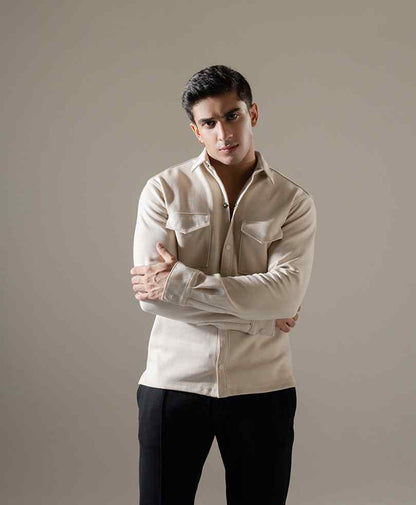 Men's beige fitted button-up shirt with long sleeves and chest pockets, side-front pose