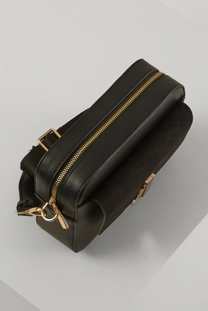 Black leather-look bag with top zipper and rounded crossbody shape, gold accents