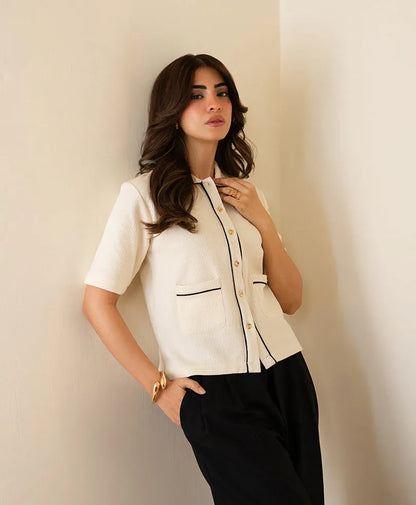 Ivory short-sleeve button-up top with stand collar, contrast trim, and chest pocket.