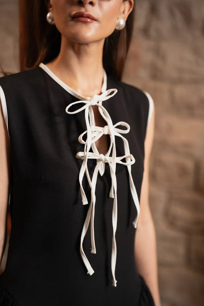 Black sleeveless dress with white lace-up bow tie neckline