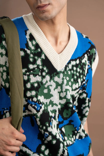 Close-up of blue V-neck sleeveless sweater vest with green and white pattern