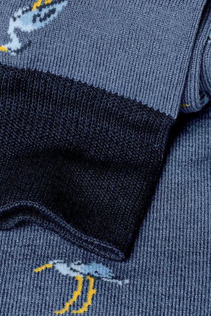 Blue socks close-up with yellow dinosaur print and ribbed cuff