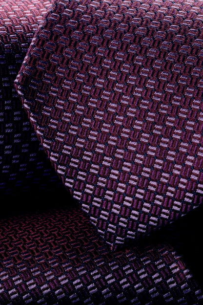 Patterned necktie close-up, dark purple and pink interlocking texture