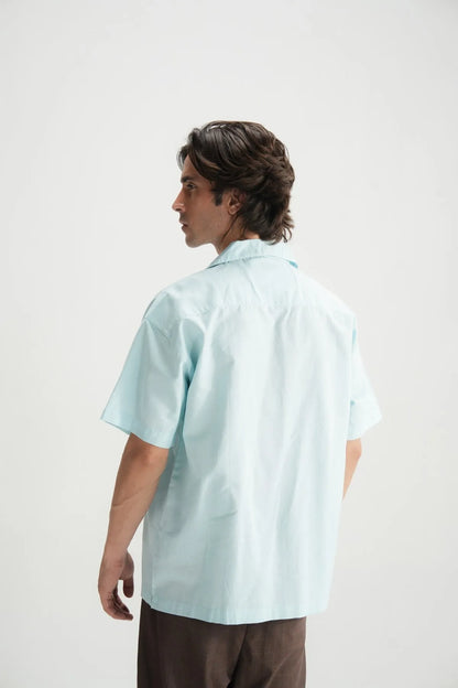 Sky blue short-sleeve button-up shirt, back side profile view