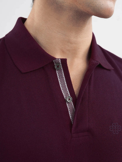Brumano burgundy polo collar and button placket with woven trim detail.