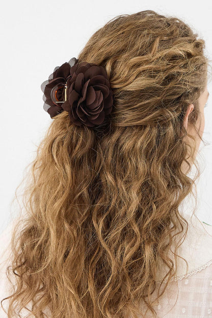 Brown fabric flower hair clip on wavy hair