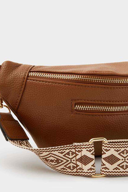 Tan belt bag close-up with textured finish and patterned webbing strap