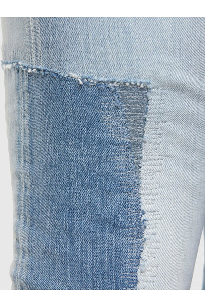 Blue denim jeans close-up of distressed fabric patch and frayed seam edge