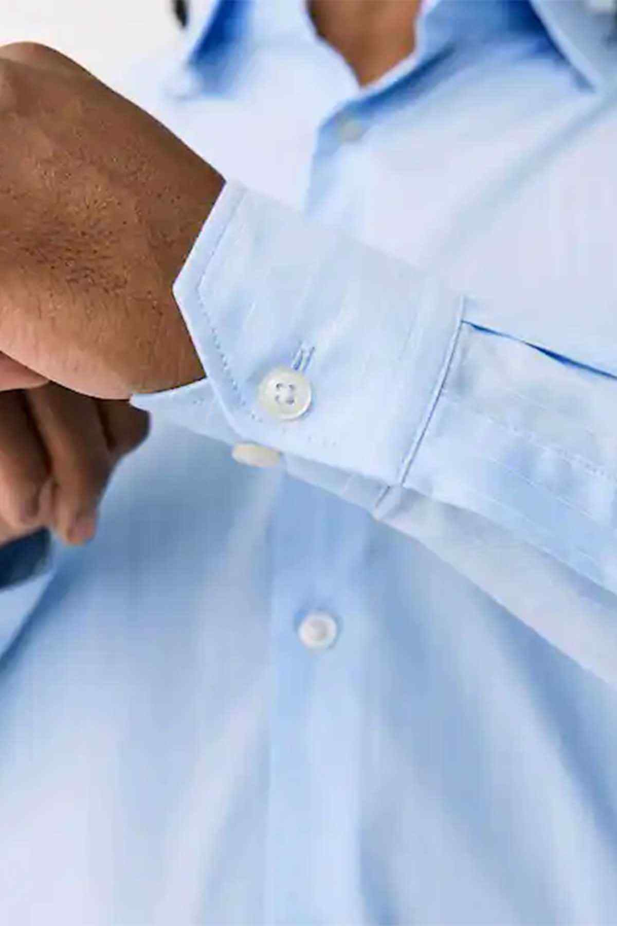 Light blue shirt cuff close-up with button and seam detail