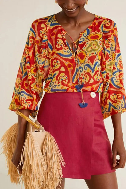 Multicolor patterned blouse with button placket, worn with red mini skirt