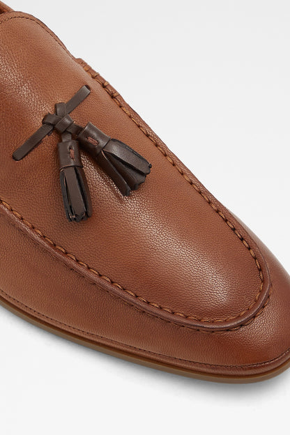 Cognac leather loafer vamp closeup with tassel ornament and stitching