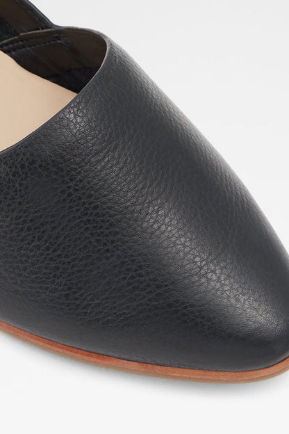 Black leather loafer upper detail with textured grain and brown edge sole