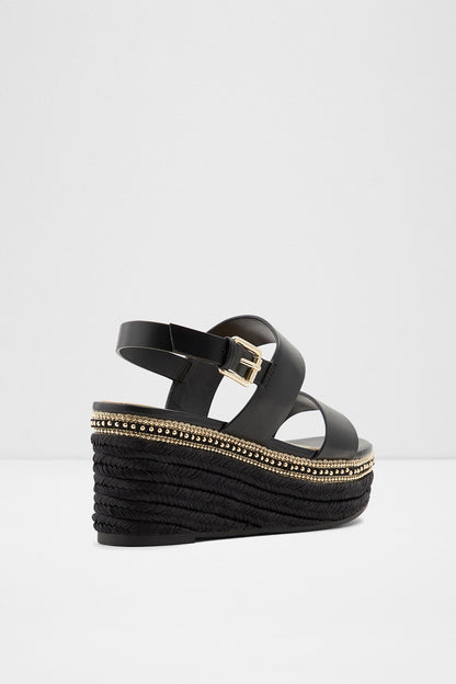 Black platform wedge sandals with crisscross straps, gold-trimmed espadrille sole