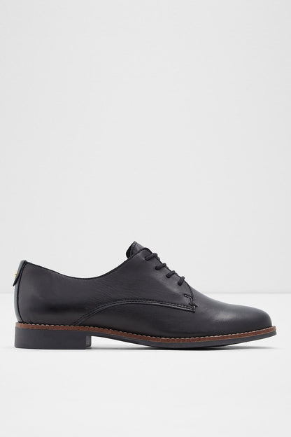 Black lace-up oxford shoe with brown sole, side view