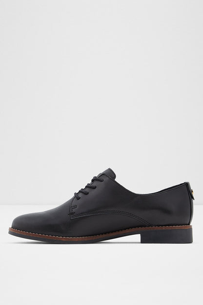 Black lace-up oxford shoe with brogue-style stitching and brown sole